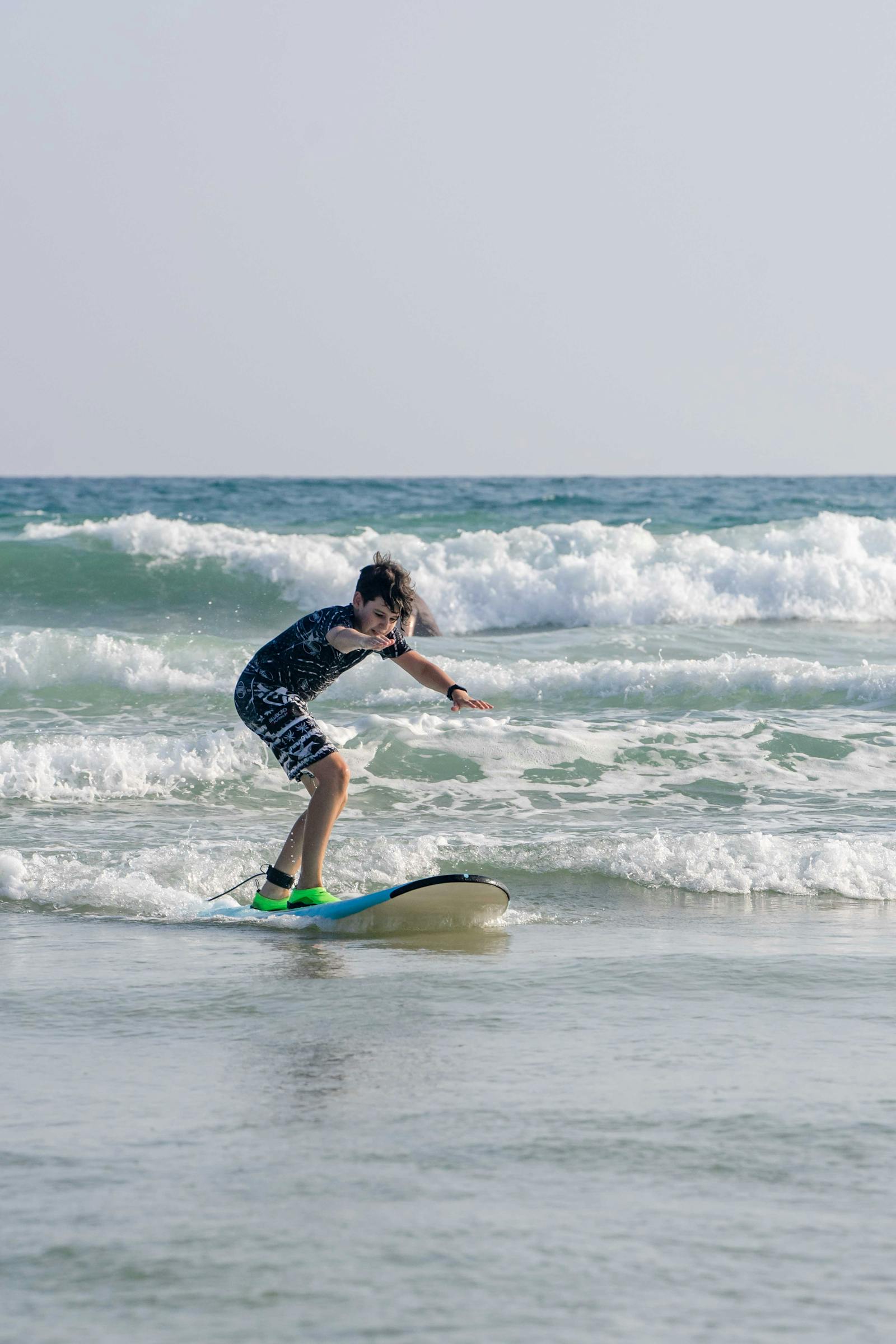 Jeune surfeur prenant une vague lors d'un cours enfant à Hossegor