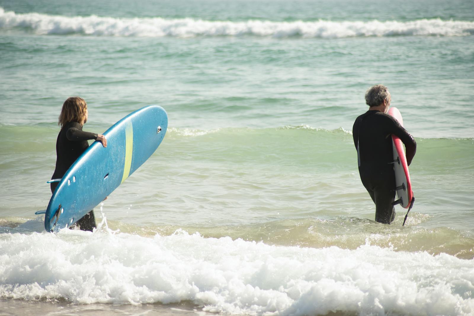 Groupe de surfeurs entrant dans l'eau, planches sous le bras, à Hossegor