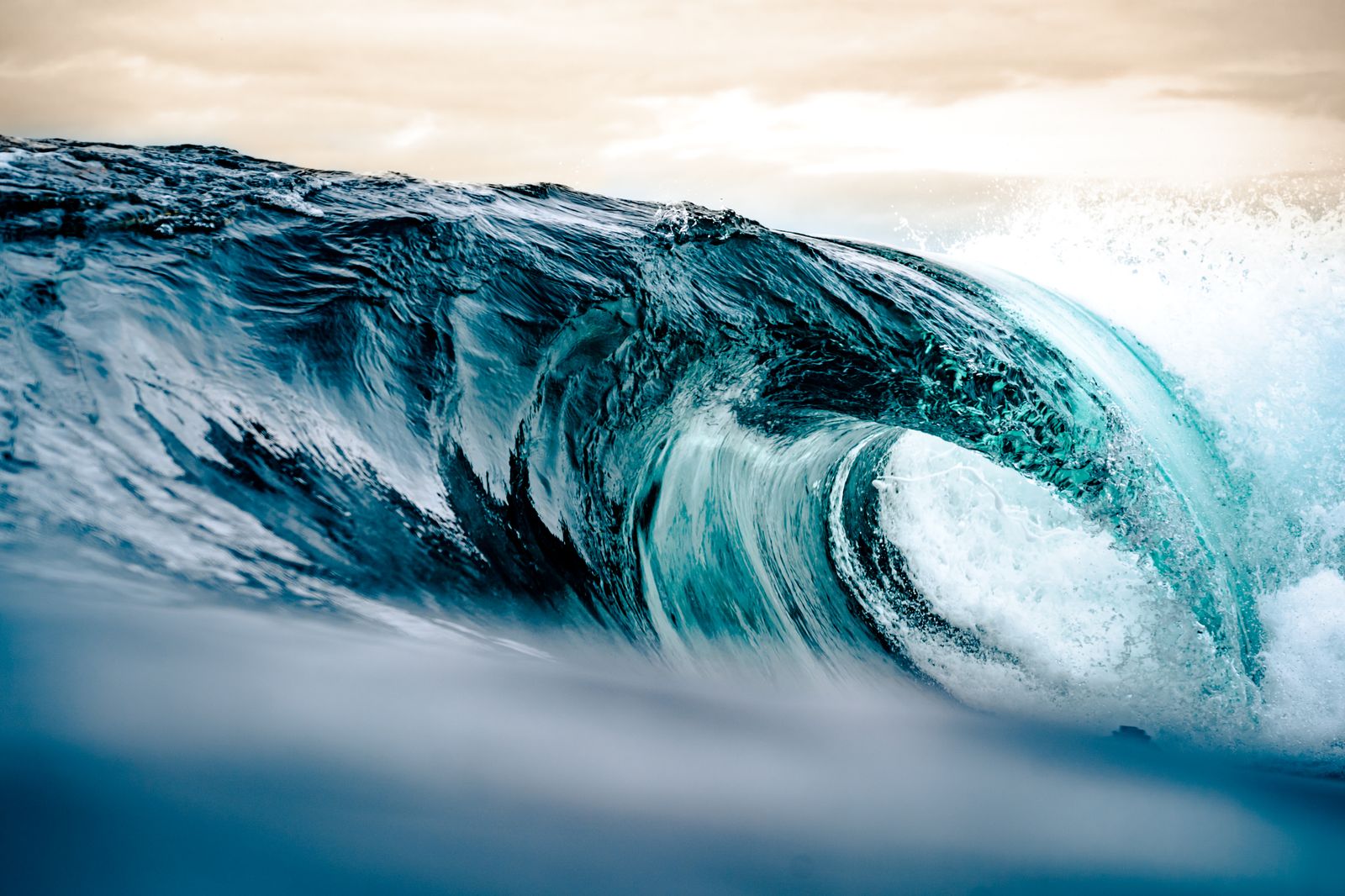 Vague tubulaire turquoise se formant au large d'Hossegor au lever du jour